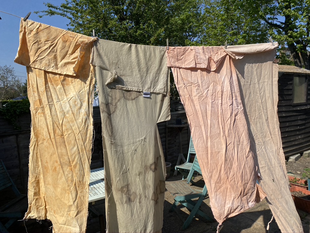 Fabric hanging on washing line colours, beige, ink and orange
