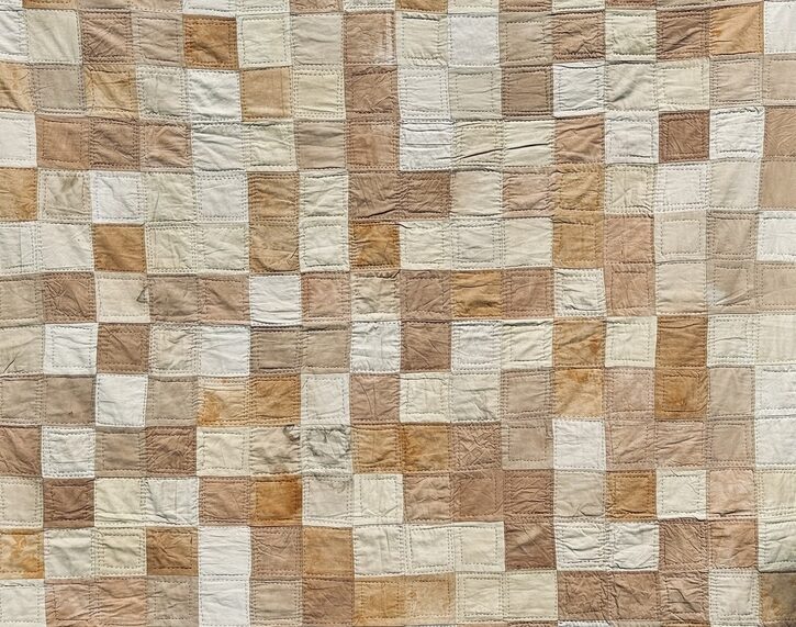 Brown quilt made of dyed fabric squares