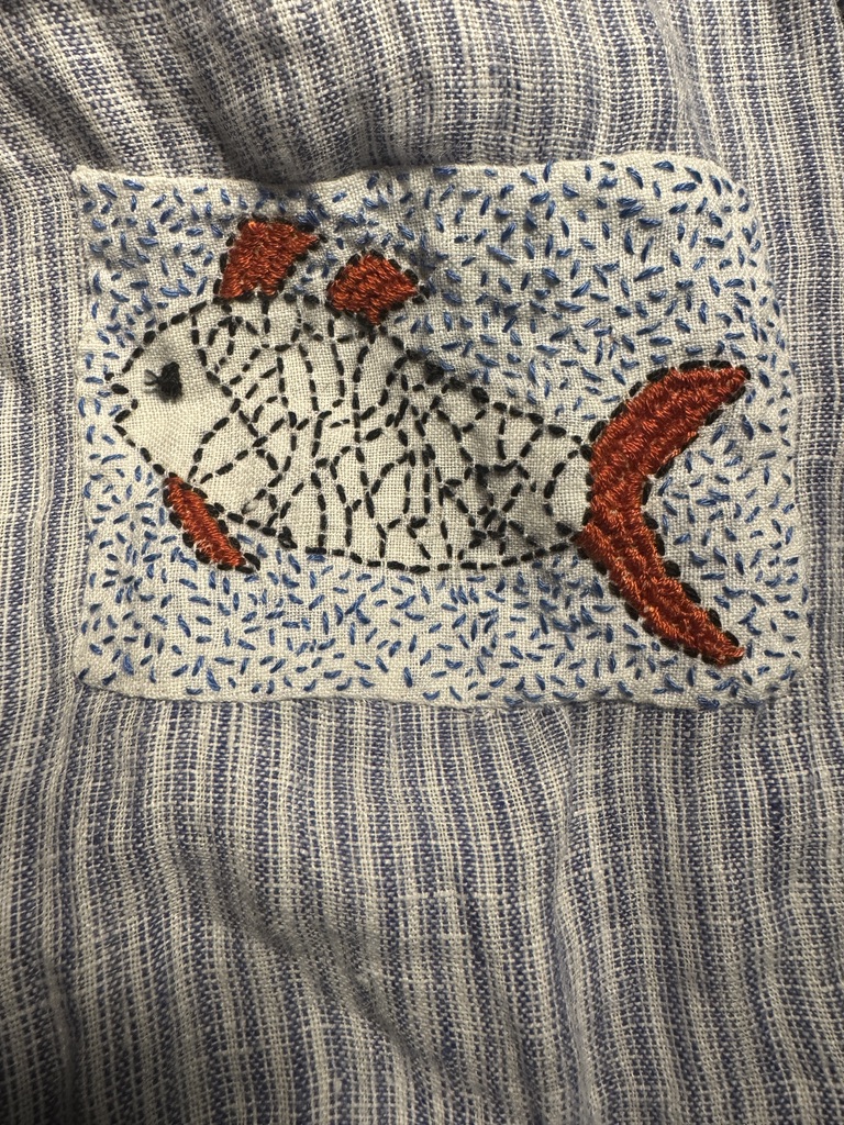 embroidered fish on striped linen cloth